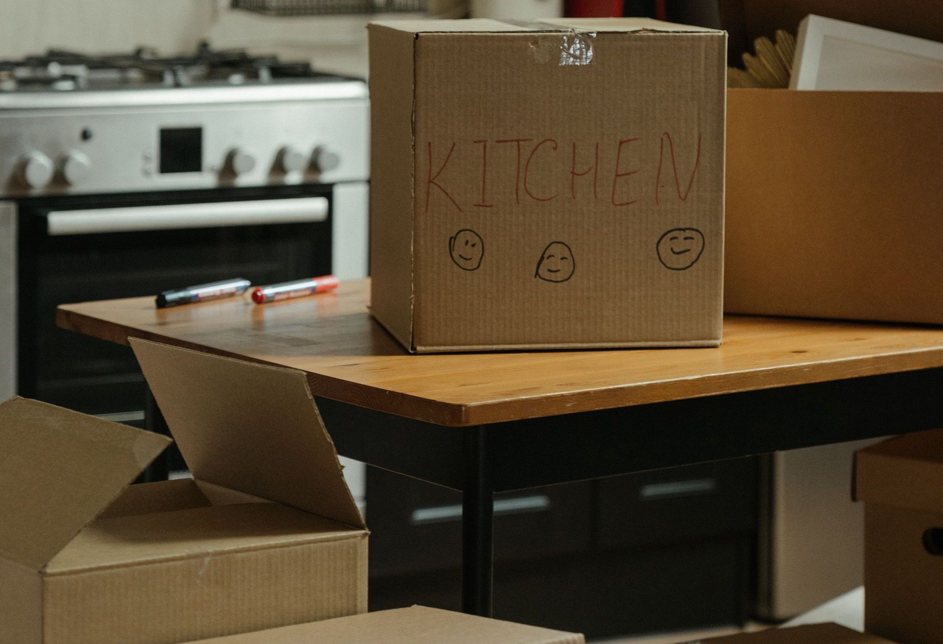 Cardboard moving boxes in a modern kitchen, ready for relocation.